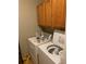 This laundry room contains a washer, a dryer, and cabinet storage at 1685 Dogwood Trl, Douglasville, GA 30134