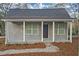 Charming gray cottage-style home with a welcoming front porch and gray roof, surrounded by trees and landscaping at 1815 River Ne St, Conyers, GA 30012