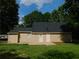 Backyard showcasing a home's exterior with a concrete patio and lush green lawn at 99 Libby Ln, Jonesboro, GA 30238