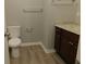 Bright bathroom features a toilet, granite countertop, and modern wood-look flooring at 99 Libby Ln, Jonesboro, GA 30238
