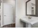 Small bathroom with pedestal sink and framed mirror at 3813 Thatcher Sw Dr, Marietta, GA 30008