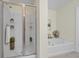 Bright bathroom with soaking tub and glass enclosed shower featuring built-in shelving at 3298 Sheffield Cir, Decatur, GA 30032