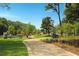 A scenic park pathway lined with trees, sculptures, and green grass, creating a tranquil outdoor escape at 318 Sandy Springs Cir # 310, Sandy Springs, GA 30328