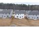 Aerial view of backyards in a new construction neighborhood featuring seeded lawns and suburban homes at 79 Hampton Ter, Dallas, GA 30157