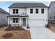 New construction two-story home featuring white siding, gray roof, covered front porch, and an attached two-car garage at 79 Hampton Ter, Dallas, GA 30157