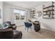 Home office with neutral carpet, floating shelves, a wood desk with blue chairs, and natural light at 79 Hampton Ter, Dallas, GA 30157