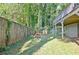 View of the large, fenced backyard with a playground set and mature trees at 1453 Midview Dr, Decatur, GA 30032