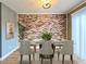 Staged dining room with brick accent wall, dining table, and chairs at 3125 Colonial Way # M, Atlanta, GA 30341