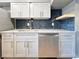 Modern kitchen with white cabinets, stainless steel dishwasher, and a blue tile backsplash at 3125 Colonial Way # M, Atlanta, GA 30341