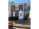 Brown siding townhouse with red shutters, white door, and small front yard at 6745 Trafalger Sq, Norcross, GA 30093