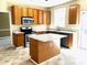 Well-lit kitchen features granite countertops, a central island, stainless steel appliances, and wooden cabinetry at 3612 Bancroft Main Nw, Kennesaw, GA 30144