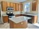 Well-lit kitchen with granite countertops, central island, stainless appliances, and wooden cabinetry at 3612 Bancroft Main Nw, Kennesaw, GA 30144