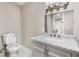 Bathroom with a toilet, vanity with modern fixtures and a large mirror at 2502 Park Dr, Lithonia, GA 30058