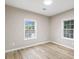 An empty bedroom with two windows, light hardwood floors, and neutral paint at 2502 Park Dr, Lithonia, GA 30058