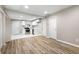 Open-concept with light wood flooring leading to the kitchen with marble floor and modern, white cabinets at 2502 Park Dr, Lithonia, GA 30058
