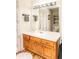 Well-lit bathroom features wood cabinetry, neutral countertop, large mirror, and wood-look flooring at 101 Emily Ln, Carrollton, GA 30116