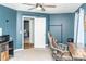 Bedroom showing desk, office chair, carpet, modern ceiling fan, and blue accent wall at 101 Emily Ln, Carrollton, GA 30116