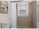 Cozy bathroom featuring a white shower curtain, white-trimmed window and tan tiled walls and floor at 242 12Th Ne St # 14, Atlanta, GA 30309