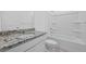 Bright bathroom featuring granite counters, a white vanity, and a shower-tub combo at 3087 Birdsong Ave, Covington, GA 30016