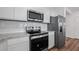 Contemporary kitchen with stainless steel appliances, granite counters and sleek, white cabinetry at 3087 Birdsong Ave, Covington, GA 30016