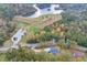 Aerial view of the home nestled among trees with a lake nearby, showcasing its serene setting at 1387 Mineral Springs Rd, Hoschton, GA 30548