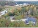 Aerial view showing the home surrounded by lush trees and a scenic lake nearby at 1387 Mineral Springs Rd, Hoschton, GA 30548
