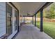 Covered outdoor porch offers a relaxing space with dark beams and well manicured backyard at 1387 Mineral Springs Rd, Hoschton, GA 30548