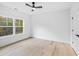 Light and airy bedroom with hardwood floors, a ceiling fan, and a large window with a wooded view at 1387 Mineral Springs Rd, Hoschton, GA 30548