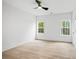 Bright bedroom with ceiling fan, light hardwood floors, and natural light at 1387 Mineral Springs Rd, Hoschton, GA 30548