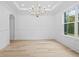 Spacious dining room with wainscoting, modern chandelier, and natural light at 1387 Mineral Springs Rd, Hoschton, GA 30548