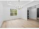 Light-filled dining room with wainscoting, chandelier, and views of the outdoors at 1387 Mineral Springs Rd, Hoschton, GA 30548