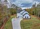 Charming home with a modern farmhouse design and a spacious driveway surrounded by lush trees at 1387 Mineral Springs Rd, Hoschton, GA 30548