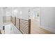 Bright hallway with modern railing, hardwood floors, and natural light at 1387 Mineral Springs Rd, Hoschton, GA 30548