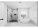 This ensuite bath showcases a glass shower, soaking tub, and modern finishes at 1387 Mineral Springs Rd, Hoschton, GA 30548