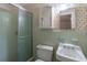 Bathroom featuring green tile, a toilet, and a shower with sliding glass door and floral wallpaper at 5655 Campbellton Sw Rd, Atlanta, GA 30331