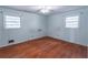 Bedroom featuring hardwood floors, two windows providing ample natural light, and neutral walls at 5655 Campbellton Sw Rd, Atlanta, GA 30331