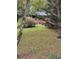 View of the front yard showcasing a brick home with a covered porch, framed by mature trees and lush greenery at 5655 Campbellton Sw Rd, Atlanta, GA 30331