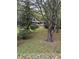Lawn view of the front yard with a brick house in the distance and several mature trees at 5655 Campbellton Sw Rd, Atlanta, GA 30331