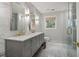 This stunning bathroom features marble countertops, gray cabinets, double sinks and a glass enclosed shower at 3047 Players Dr, Jonesboro, GA 30236