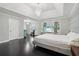 This bedroom features a tray ceiling, dark hardwood floors, an elegant chandelier, and a television at 3047 Players Dr, Jonesboro, GA 30236