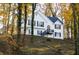 Two-story white house with black shutters, nestled among autumn trees at 7205 Jonsway, Cumming, GA 30041