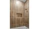 Bathroom shower with wood look tile walls and an inset shelf for shower products at 3785 Lower Roswell Rd, Marietta, GA 30068