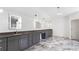 Bright bathroom with marble floors, a long vanity with a grey countertop, and multiple illuminated mirrors at 3785 Lower Roswell Rd, Marietta, GA 30068