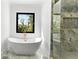 Luxurious bathroom featuring a freestanding tub, a large window, and a glass shower enclosure at 3785 Lower Roswell Rd, Marietta, GA 30068