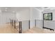 Bright hallway with wooden floors, modern railings, and a stylish light fixture above the staircase at 3785 Lower Roswell Rd, Marietta, GA 30068