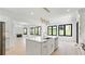 Bright open kitchen boasts a white island, modern light fixture, black frame windows and an open view to the living room at 3785 Lower Roswell Rd, Marietta, GA 30068