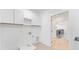 Bright laundry room with white cabinetry and tile flooring, conveniently located near the bathroom at 3785 Lower Roswell Rd, Marietta, GA 30068