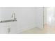 Well-lit laundry area with a stainless steel sink and white cabinets for storage at 3785 Lower Roswell Rd, Marietta, GA 30068