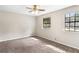 A bright bedroom with two windows, ceiling fan, plush carpeting, and neutral walls at 1185 Oak Villas Nw Ct, Conyers, GA 30012