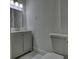 Modern bathroom with gray vanity, white toilet, and marble-look flooring at 773 Harwell Nw Rd, Atlanta, GA 30318